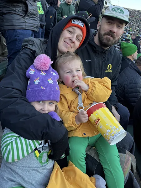 The Flannery family sit in Autzen Stadium, bundled in warm clothing.