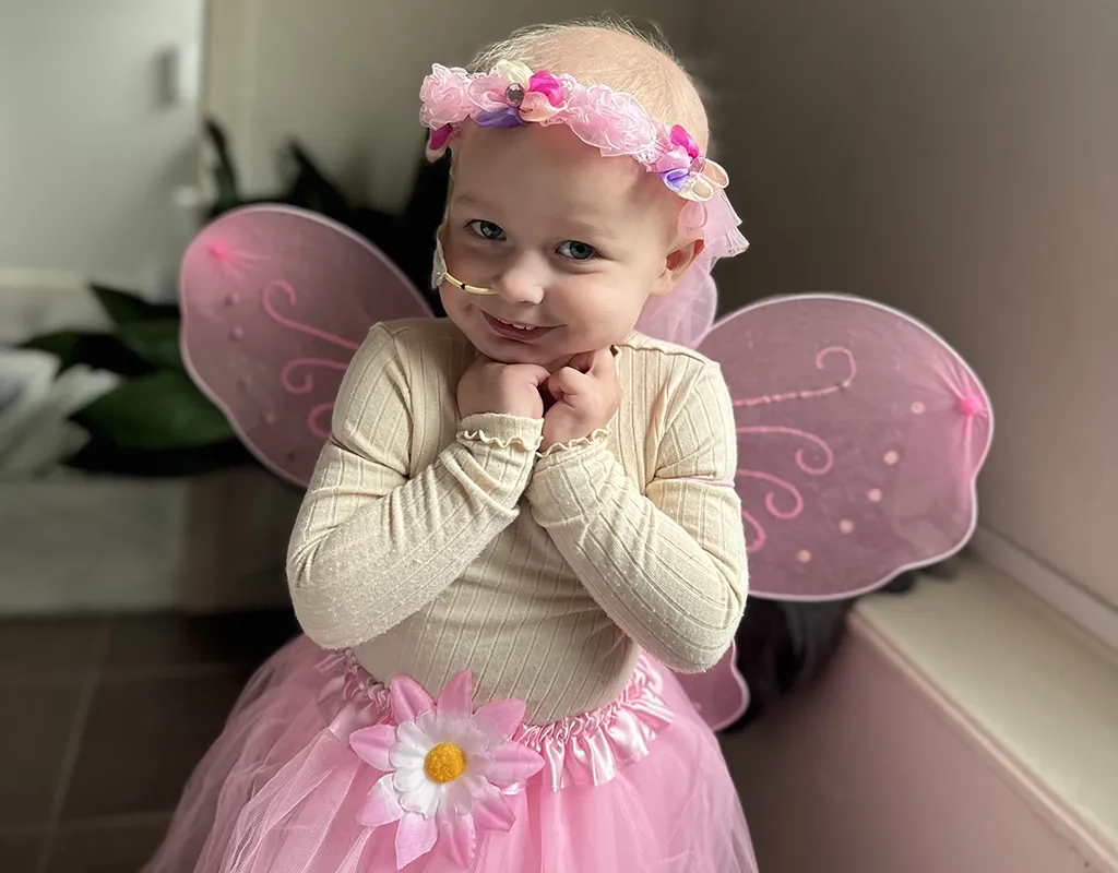 Shea wearing a pink tutu and wings dressed up in a flower crown as a fairy during treatment.
