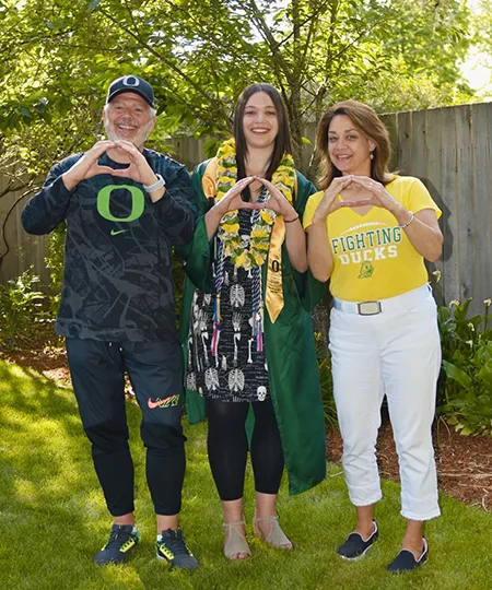 Darren Des Roches, his wife pose with their daughter in her graduation regalia.