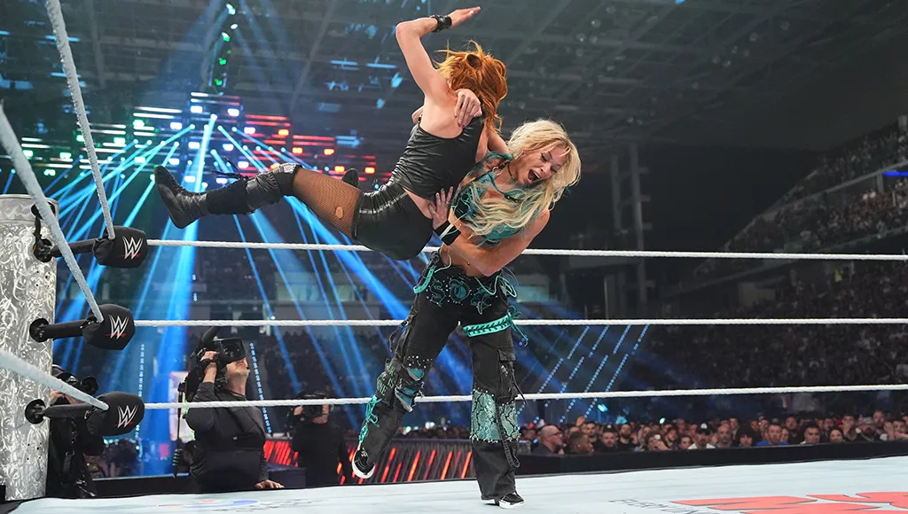 Sol Ruca lifts Becky Lynch up, about to slam her into the floor of the ring at WWE's Clash in Italy.